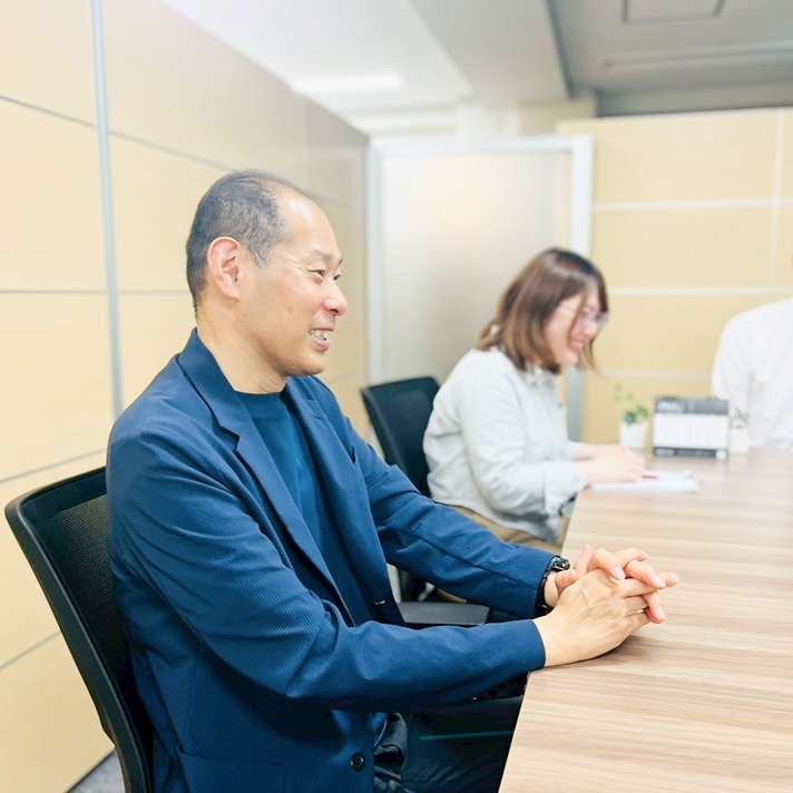 会議室で和やかに打ち合わせをする社員の様子